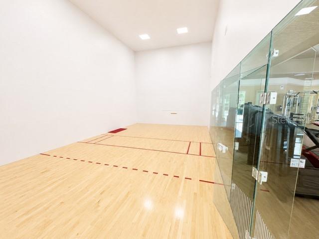 An indoor racquetball court features light wood flooring and white walls — 17102 CARRINGTON PARK DRIVE UNIT 302, TAMPA, FL