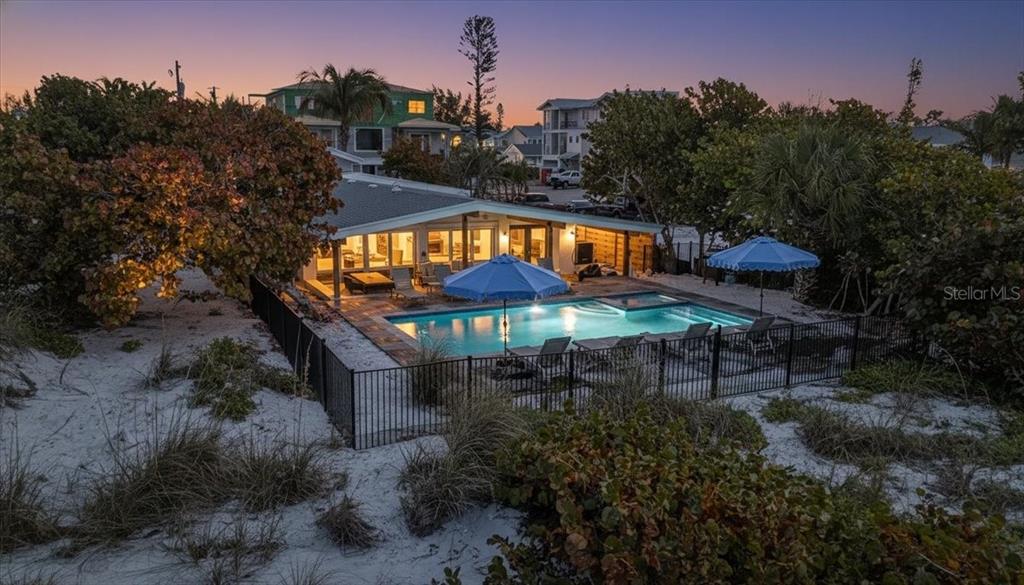 An aerial view of a beach house with a swimming pool and two blue umbrellas — 102 TUNA STREET, ANNA MARIA, FL