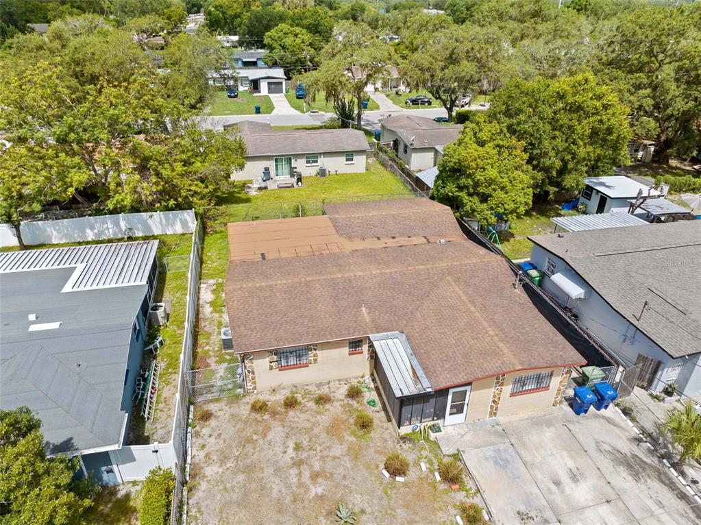 An aerial view shows a single-story house with a brown roof and a concrete driveway — 10412 N ALTMAN STREET, TAMPA, FL
