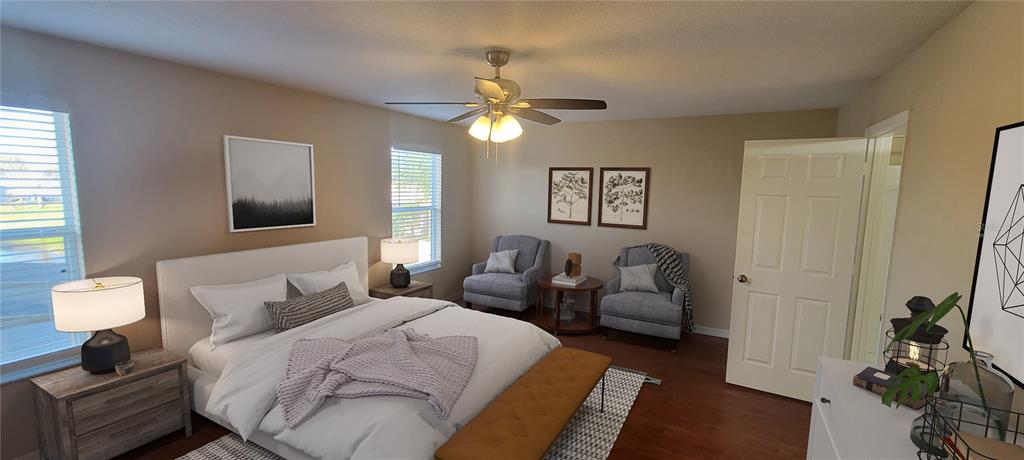 A bedroom features a bed with white bedding, two armchairs, and a ceiling fan — 15461 GALBI DRIVE, ORLANDO, FL