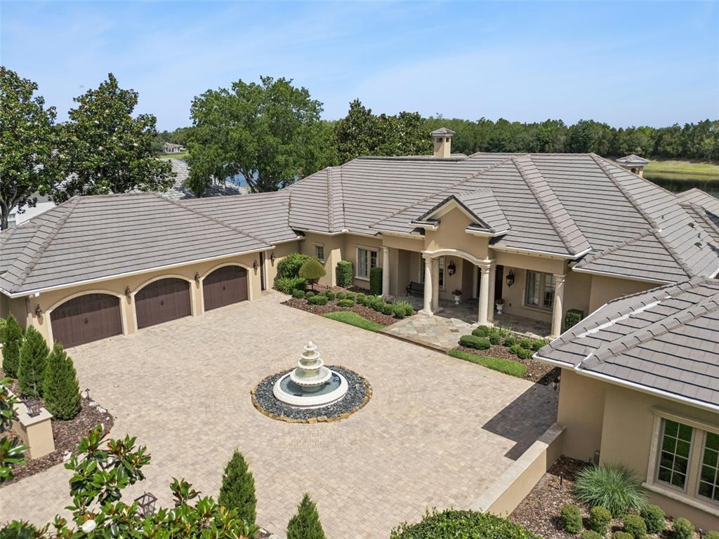 An aerial view shows a large house with a three-car garage and a circular fountain — 9225 BEVINGTON LANE, ORLANDO, FL