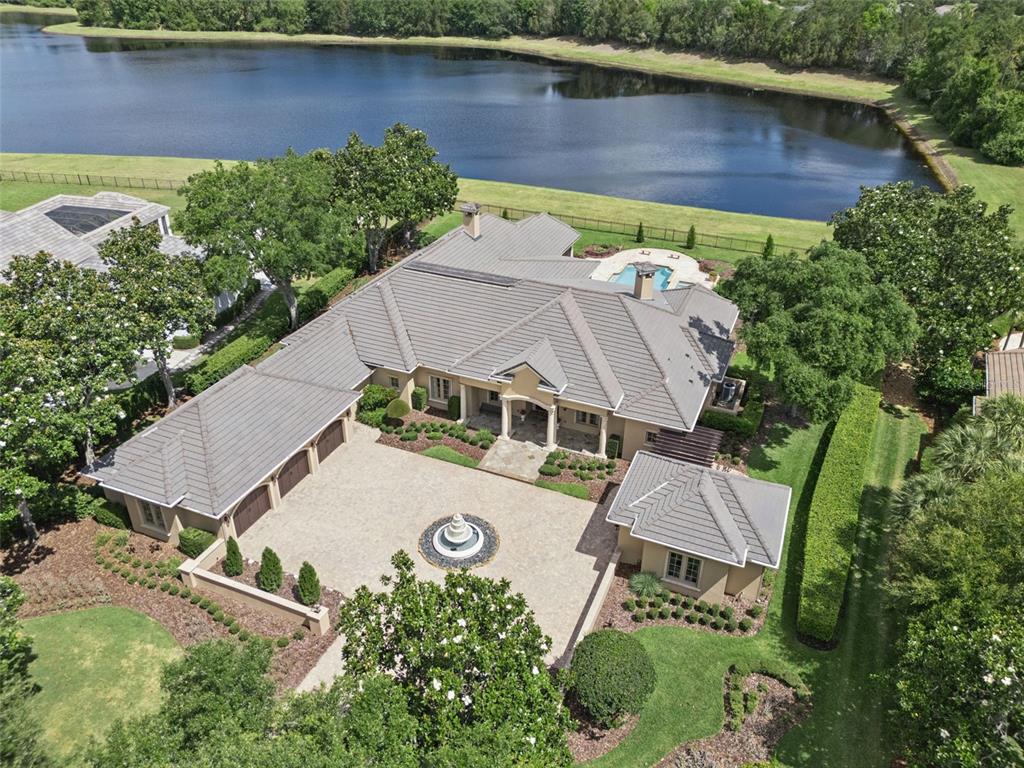 An aerial view shows a large house with a circular fountain in the paved driveway — 9225 BEVINGTON LANE, ORLANDO, FL