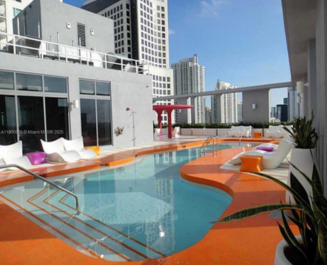 An outdoor swimming pool with orange decking and lounge chairs on a building rooftop — 31 SE 6th St # 2508, Miami FL 33131, MIAMI, FL