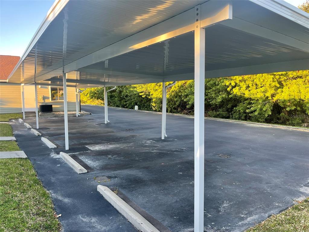 An outdoor covered parking area with multiple metal support posts and concrete wheel stops — 10225 ULMERTON ROAD UNIT 7C, LARGO, FL