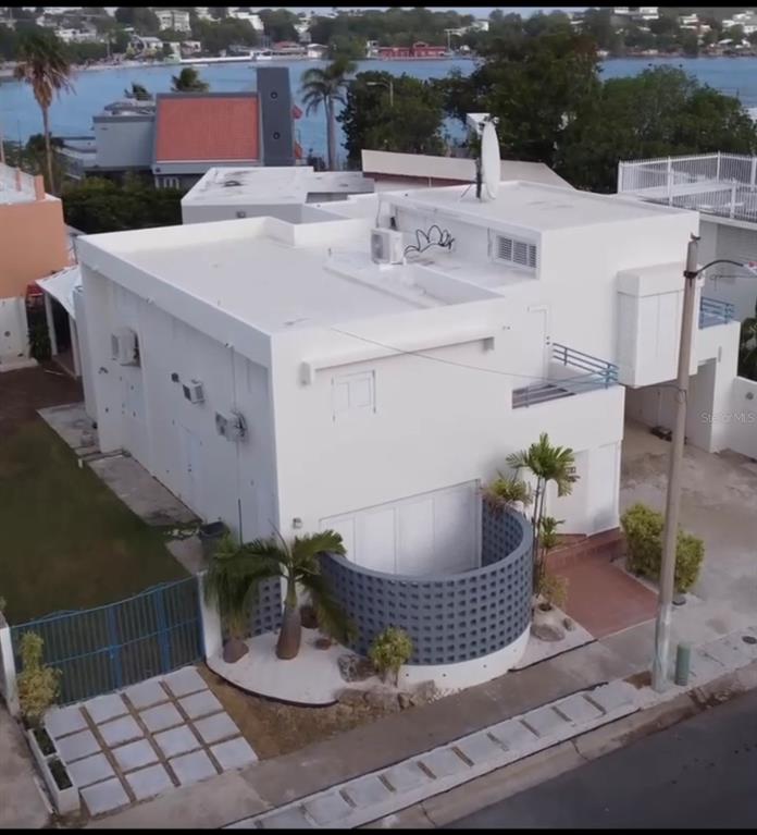 An aerial view of a white two-story house featuring a curved blue decorative block wall — 75 FRAGATA UNIT 75, GUANICA, PR