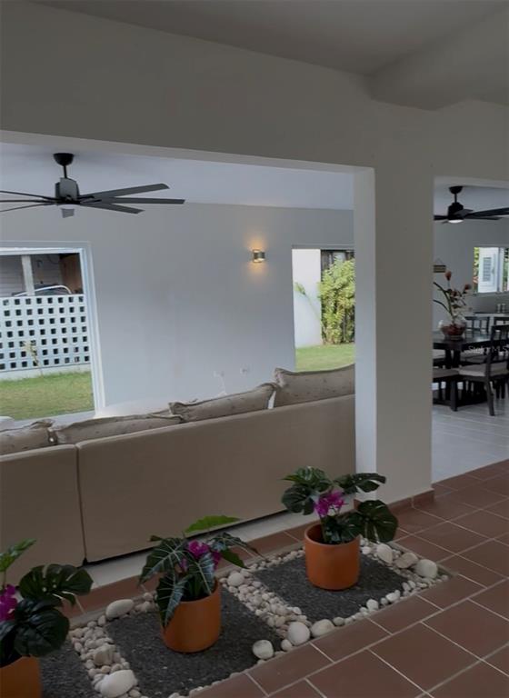 An open-concept living and dining area features tiled floors, ceiling fans, and indoor planters — 75 FRAGATA UNIT 75, GUANICA, PR