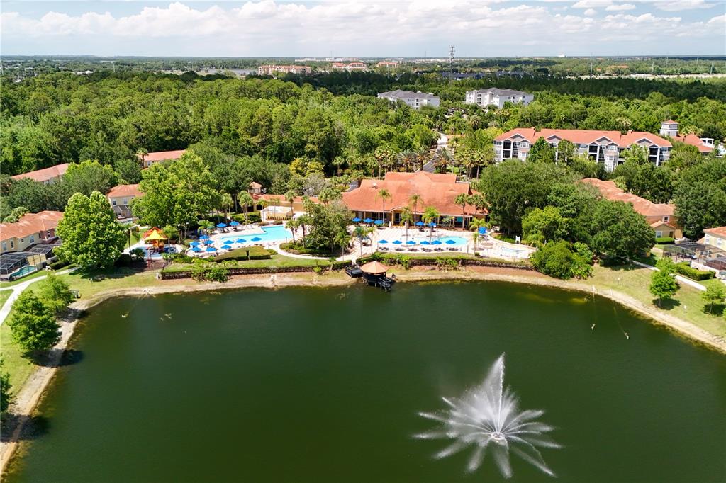 An aerial view of a community clubhouse with a swimming pool and a fountain lake — 3003 BIRD OF PARADISE LANE, KISSIMMEE, FL
