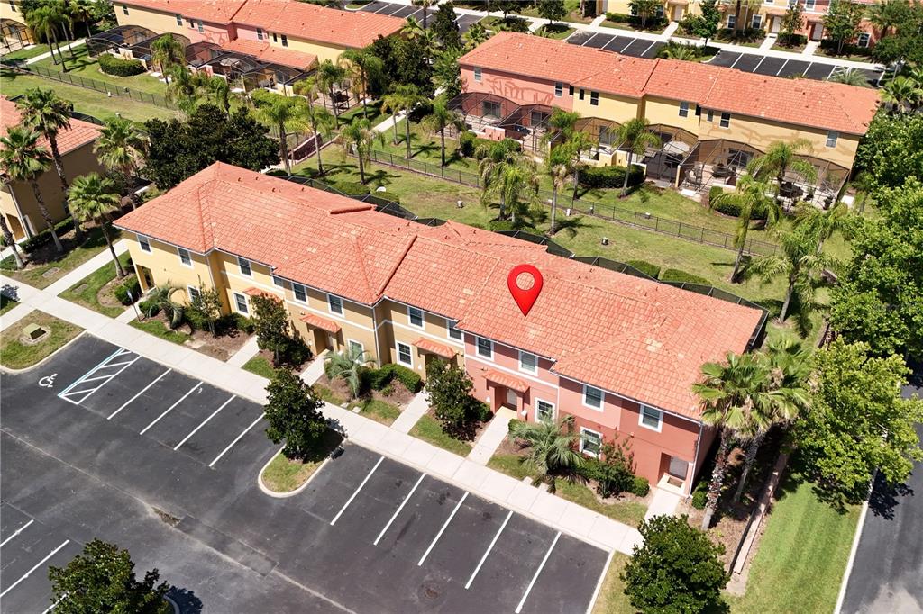 An aerial view shows a multi-unit residential building with a red tile roof and parking — 3003 BIRD OF PARADISE LANE, KISSIMMEE, FL