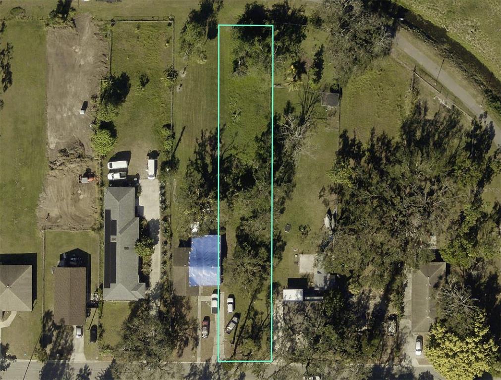 An aerial view shows a narrow, rectangular residential lot outlined in light blue — 302 12TH STREET W, PALMETTO, FL