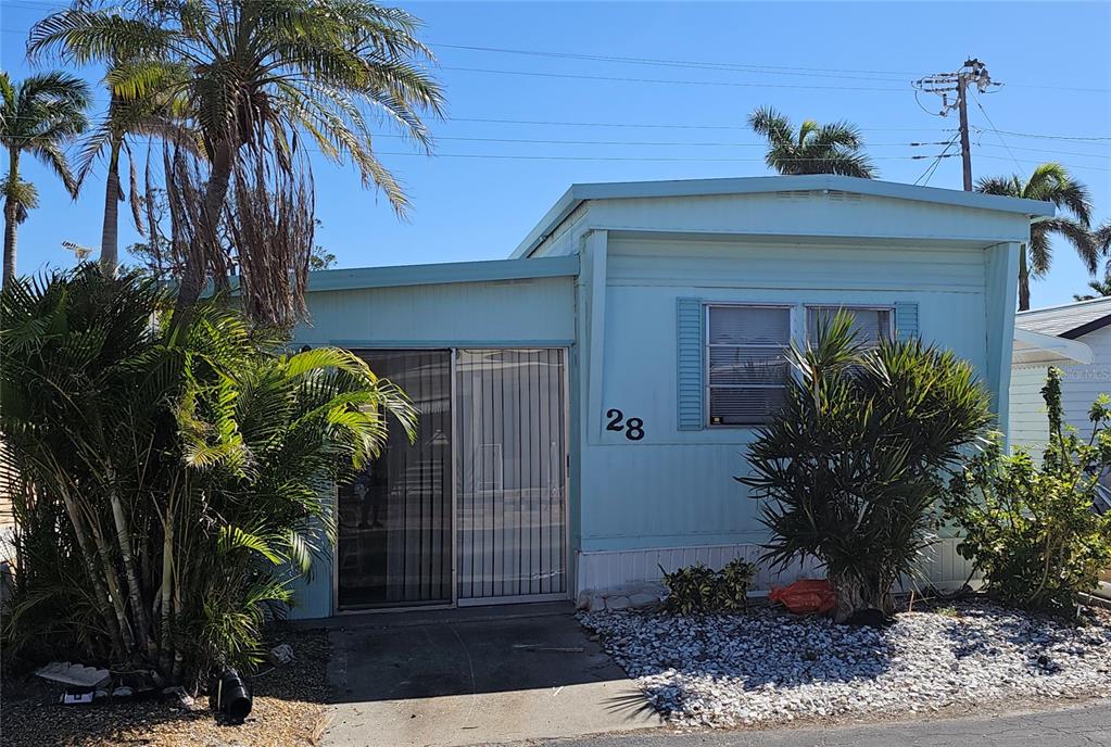 A light blue mobile home with a sliding glass door and the number 28 displayed — 10315 CORTEZ ROAD W UNIT 28-1, BRADENTON, FL