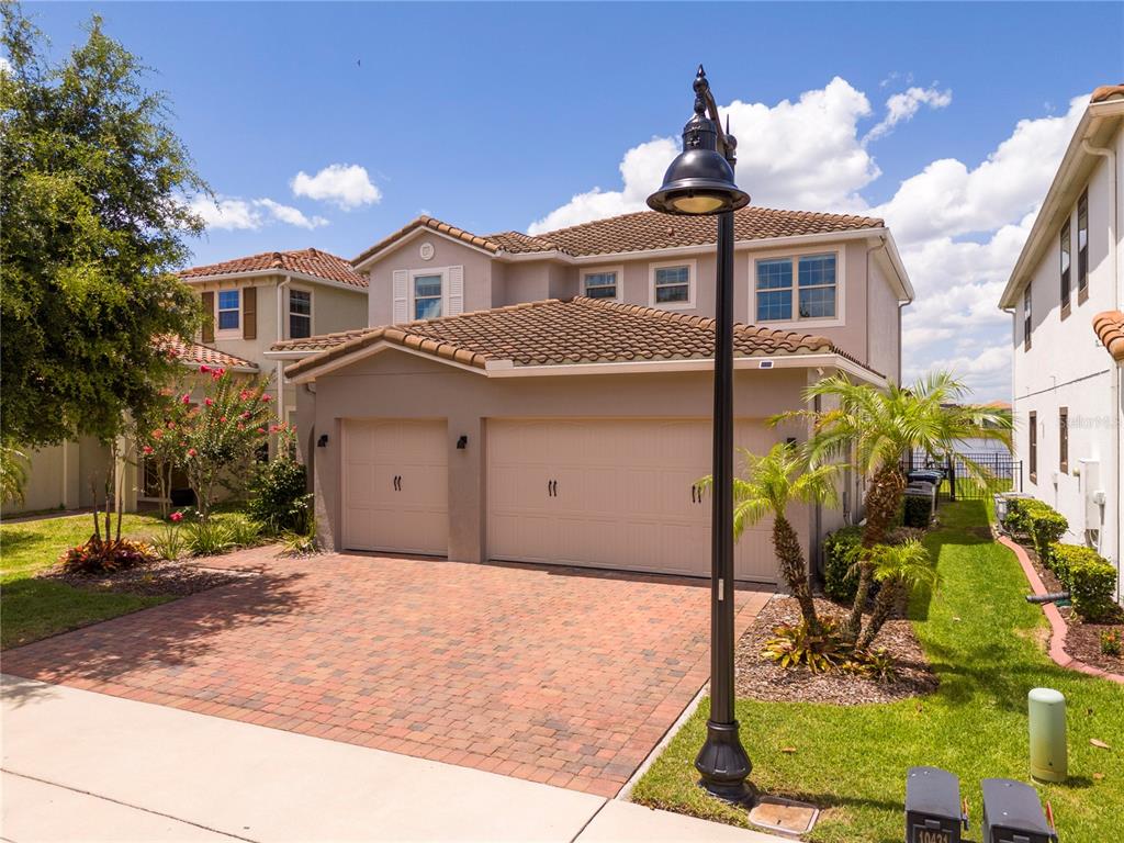 A two-story house with a three-car garage and a brick paver driveway — 10431 SIDDINGTON DRIVE, ORLANDO, FL