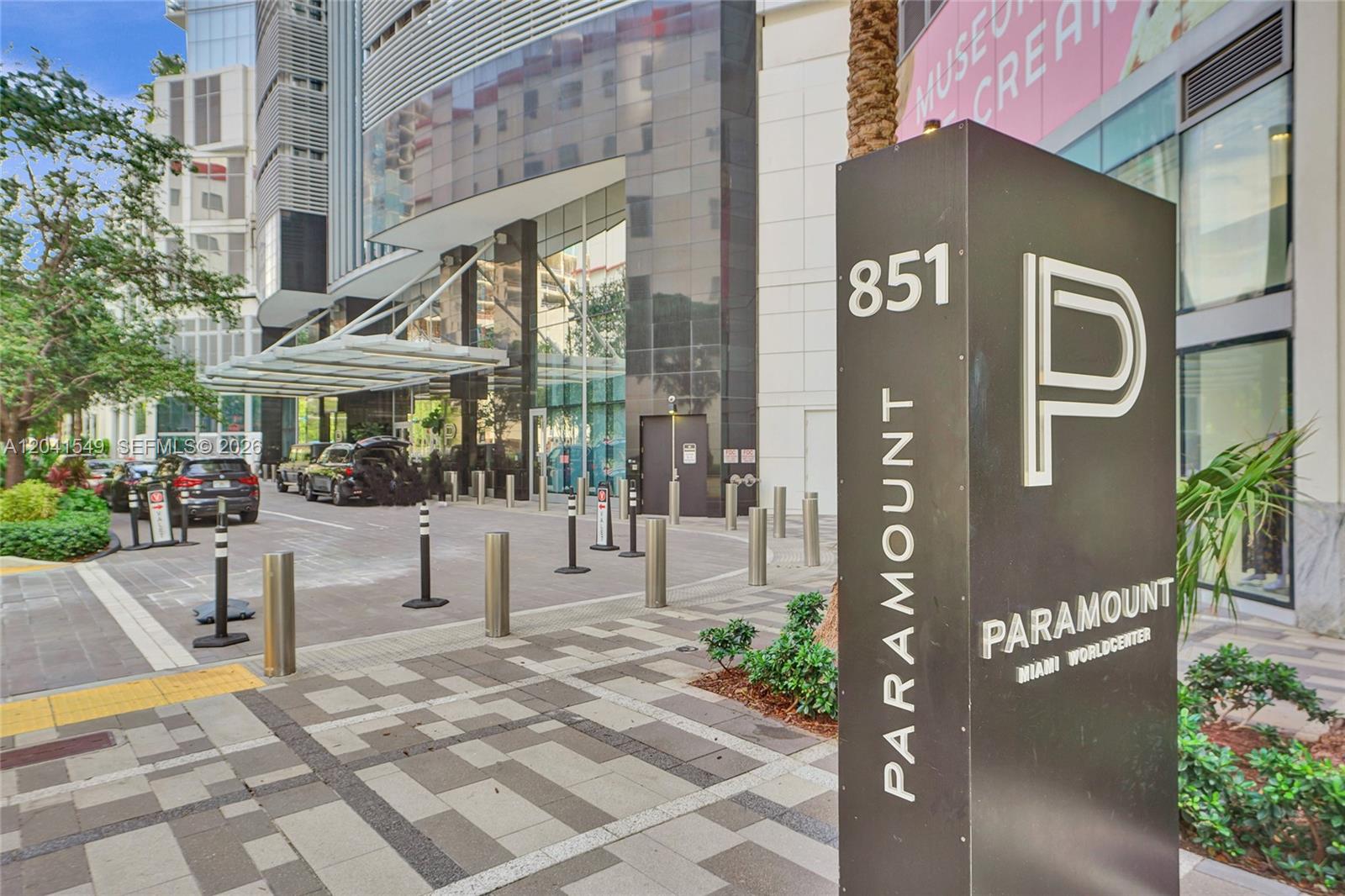A sign for Paramount Miami Worldcenter stands on a sidewalk in front of a building entrance — 851 NE 1st Ave # 3800, Miami FL 33132, MIAMI, FL