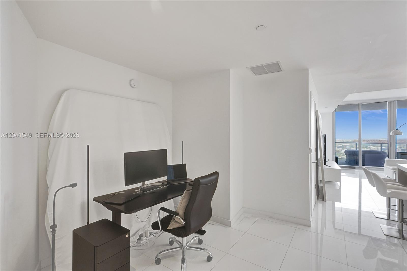 A home office area features a dark desk, an office chair, and white tile flooring — 851 NE 1st Ave # 3800, Miami FL 33132, MIAMI, FL