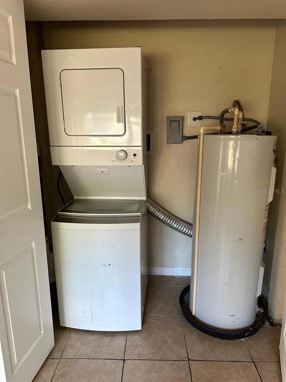 A laundry closet contains a stacked washer-dryer unit next to a water heater — 108 EDGEWATER DRIVE, WINTER HAVEN, FL