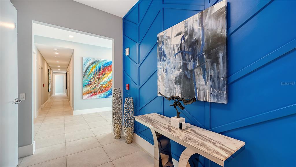 A hallway features a blue accent wall with geometric molding, a console table, and artwork — 540 N TAMIAMI TRAIL UNIT 804, SARASOTA, FL