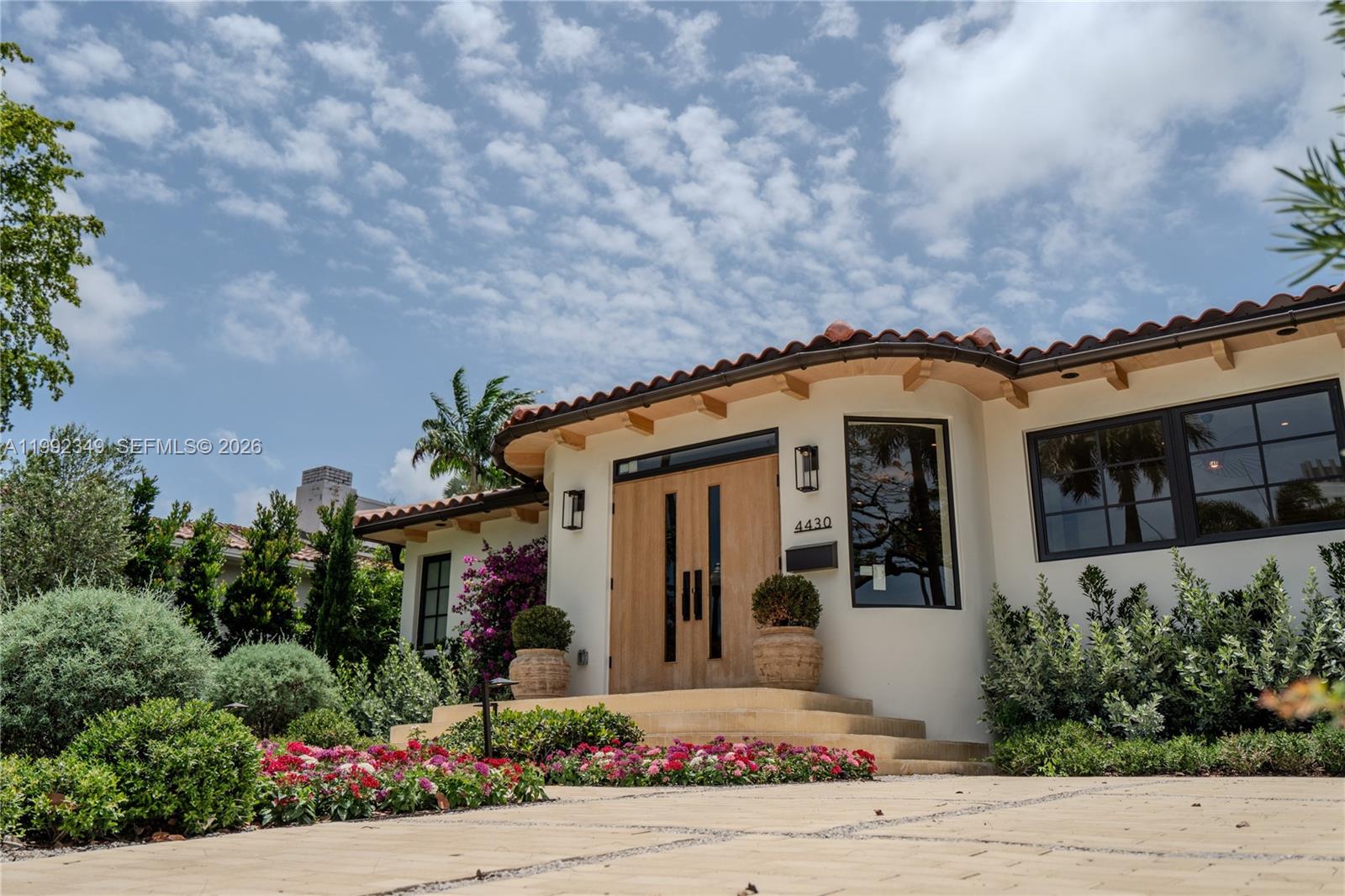 A white stucco house features a curved entryway, wooden double doors, and a tiled roof — 4430 Royal Palm Ave, Miami Beach FL 33140, MIAMI BEACH, FL