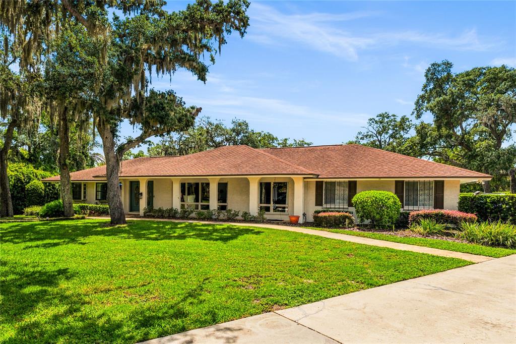 A single-story ranch-style house with a brown roof sits behind a large green lawn — 111 LITTLE OAK LANE, ALTAMONTE SPRINGS, FL