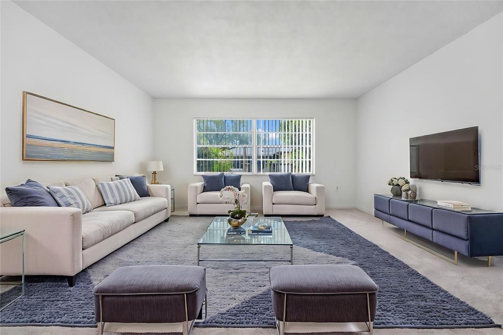 A living room features a beige sofa, two armchairs, a glass coffee table, and blue accents — 5060 ANDREA BOULEVARD, ORLANDO, FL