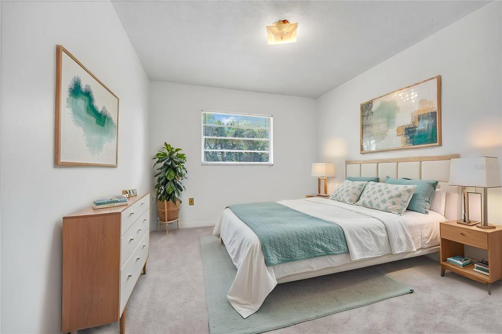 A bedroom features a bed with teal bedding, a wooden dresser, and two framed artworks — 5060 ANDREA BOULEVARD, ORLANDO, FL