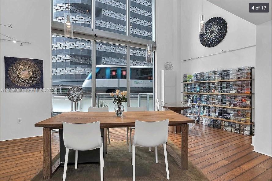 A dining room features a wooden table, white chairs, and a large wall of storage bins — 1050 Brickell Ave # 208, Miami FL 33131, MIAMI, FL