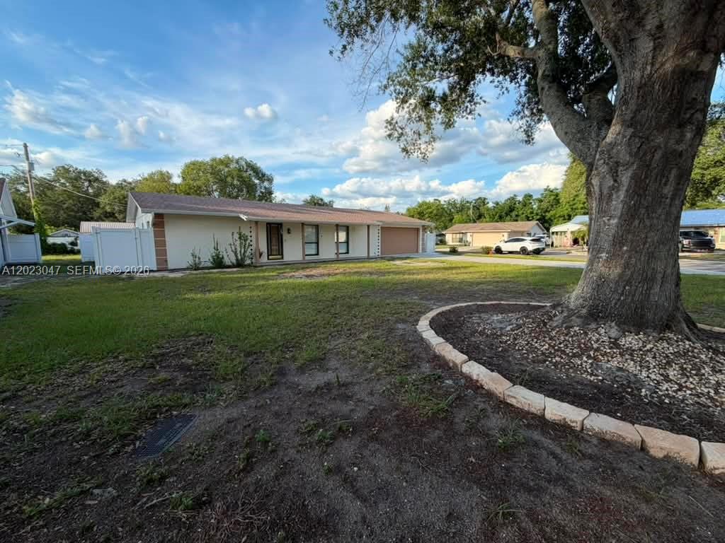 A single-story house with a tan exterior, a two-car garage, and a large front tree — 1210 BRANDA VISTA DR, Brandon FL 33510, BRANDON, FL