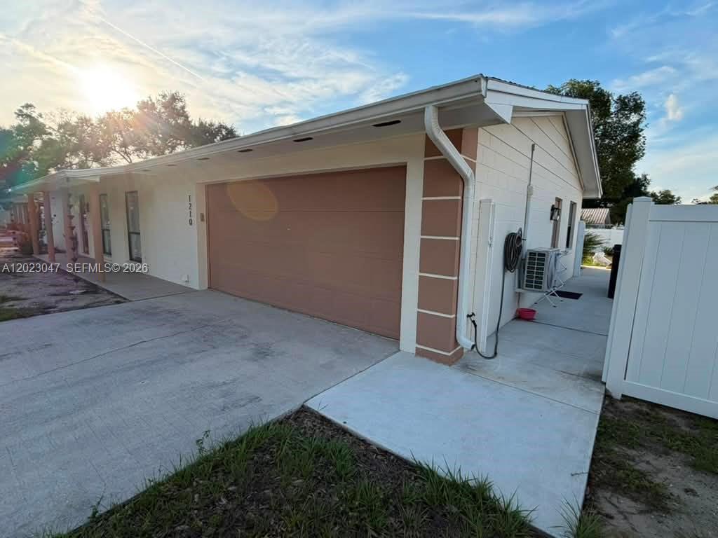 A single-story house exterior features a two-car garage, white concrete block walls, and a driveway — 1210 BRANDA VISTA DR, Brandon FL 33510, BRANDON, FL