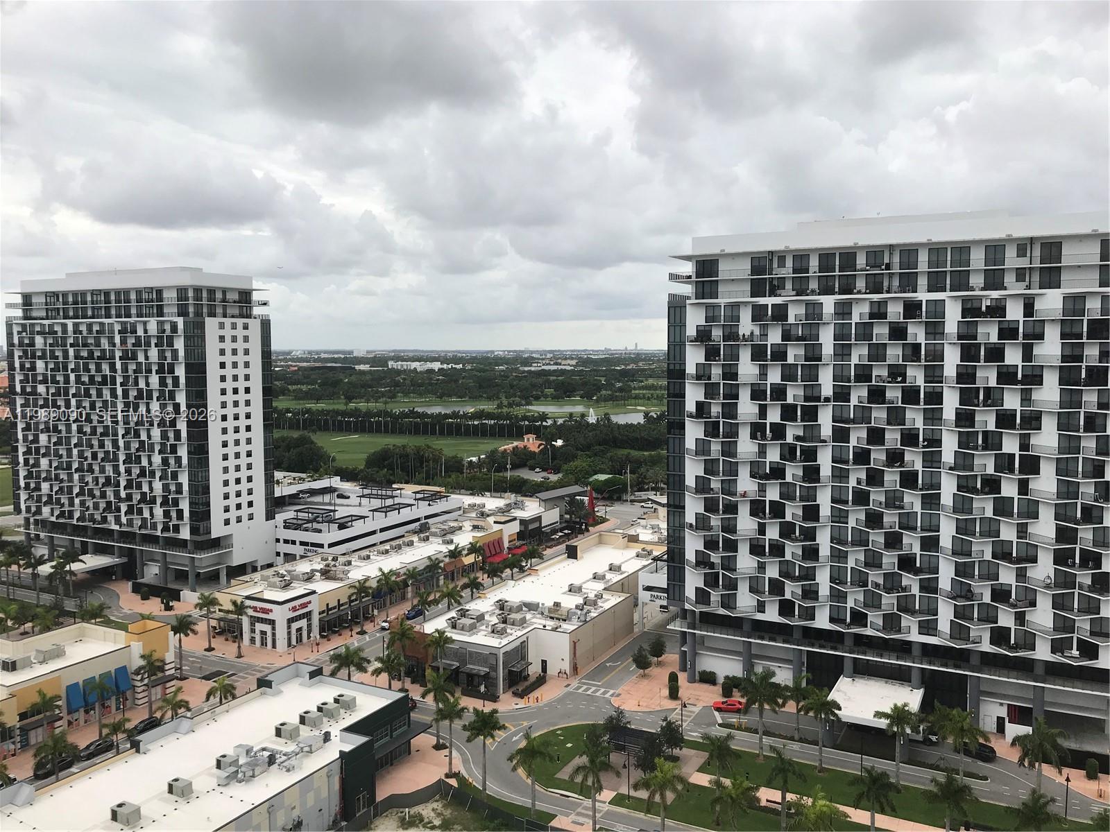 An elevated view shows two modern high-rise apartment buildings flanking a commercial plaza with palm trees — 5350 NW 84th Ave # 1814, Doral FL 33166, DORAL, FL