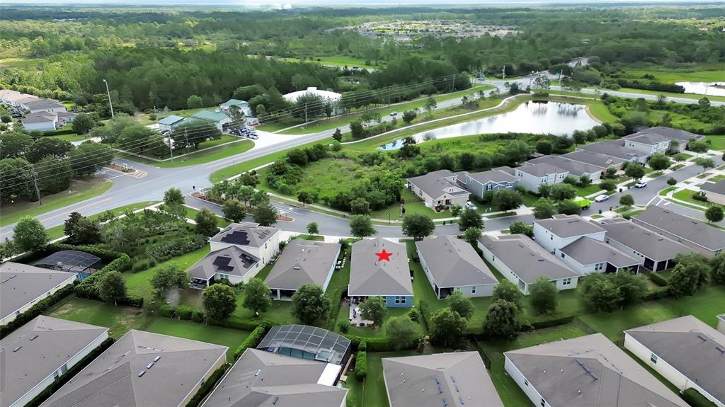 An aerial view shows a suburban neighborhood with a blue house marked by a red star — 744 E VICTORIA TRAILS BOULEVARD, DELAND, FL