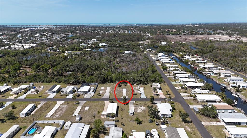 An aerial view shows a vacant residential lot marked with a red circle in a neighborhood — 1256 IBIS DRIVE, ENGLEWOOD, FL