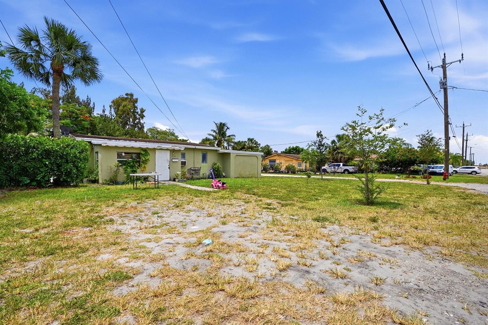 A single-story green house with a large front yard and a palm tree — 700 SW 8th Street, Pompano Beach FL 33060, POMPANO BEACH, FL