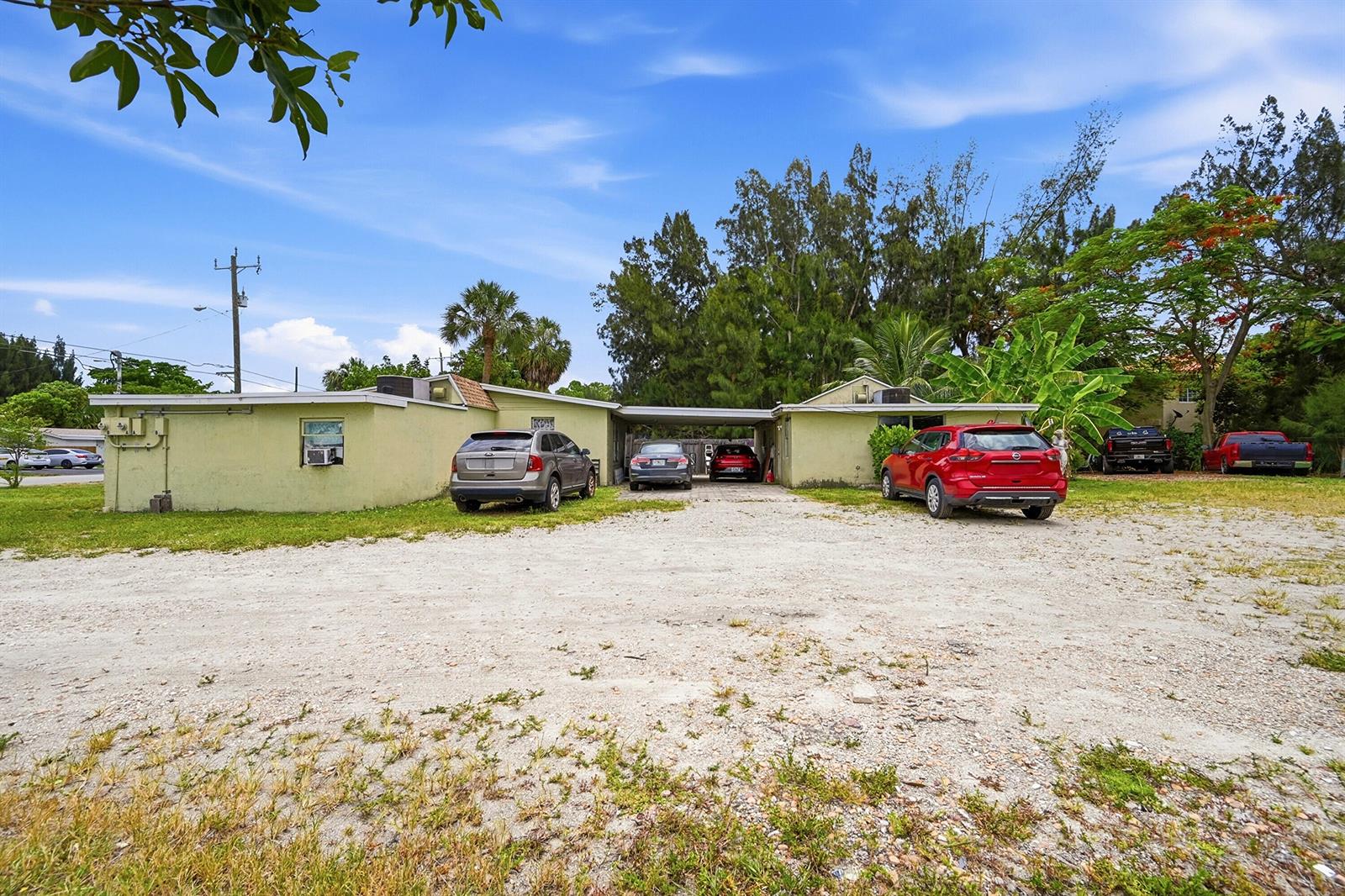 A single-story, light green house with a gravel driveway and multiple parked vehicles — 700 SW 8th Street, Pompano Beach FL 33060, POMPANO BEACH, FL