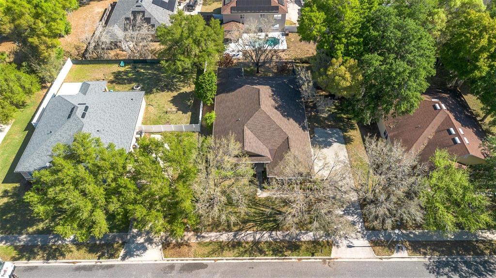 An aerial view shows three suburban houses with brown and gray roofs surrounded by trees — 2613 BREEZY MEADOW ROAD, APOPKA, FL