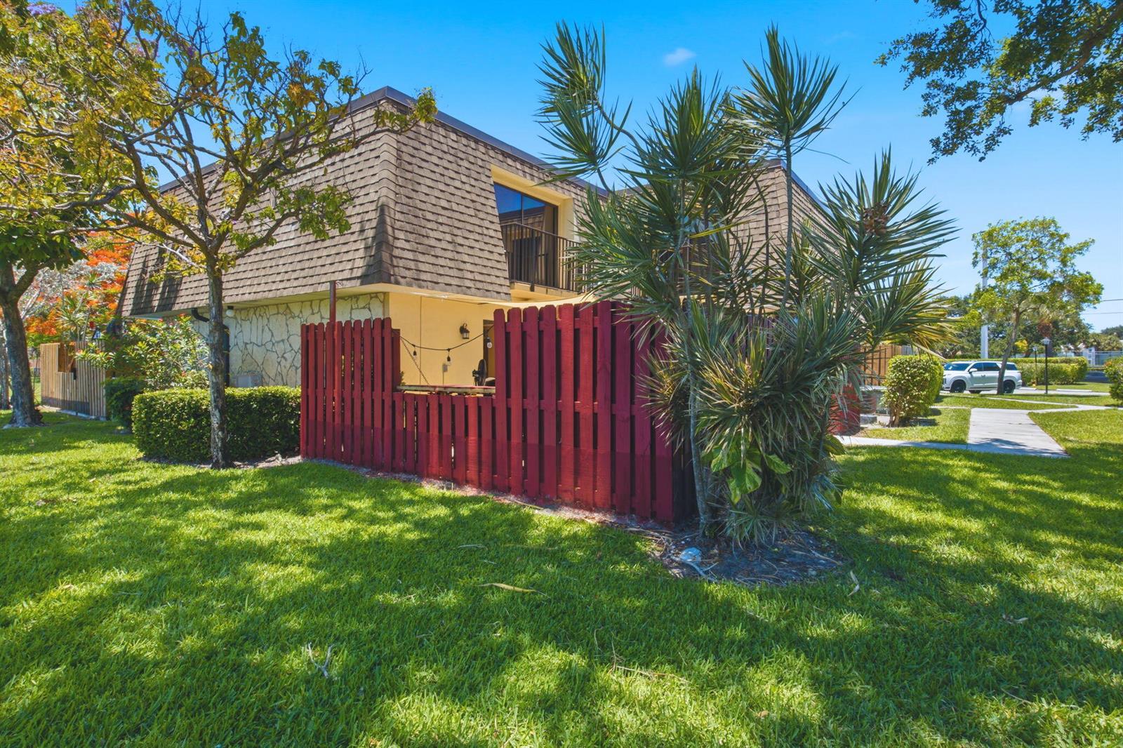A two-story building with a red wooden fence enclosing a patio area on the lawn — 2883 SW 22nd Circle # 51a, Delray Beach FL 33445, DELRAY BEACH, FL