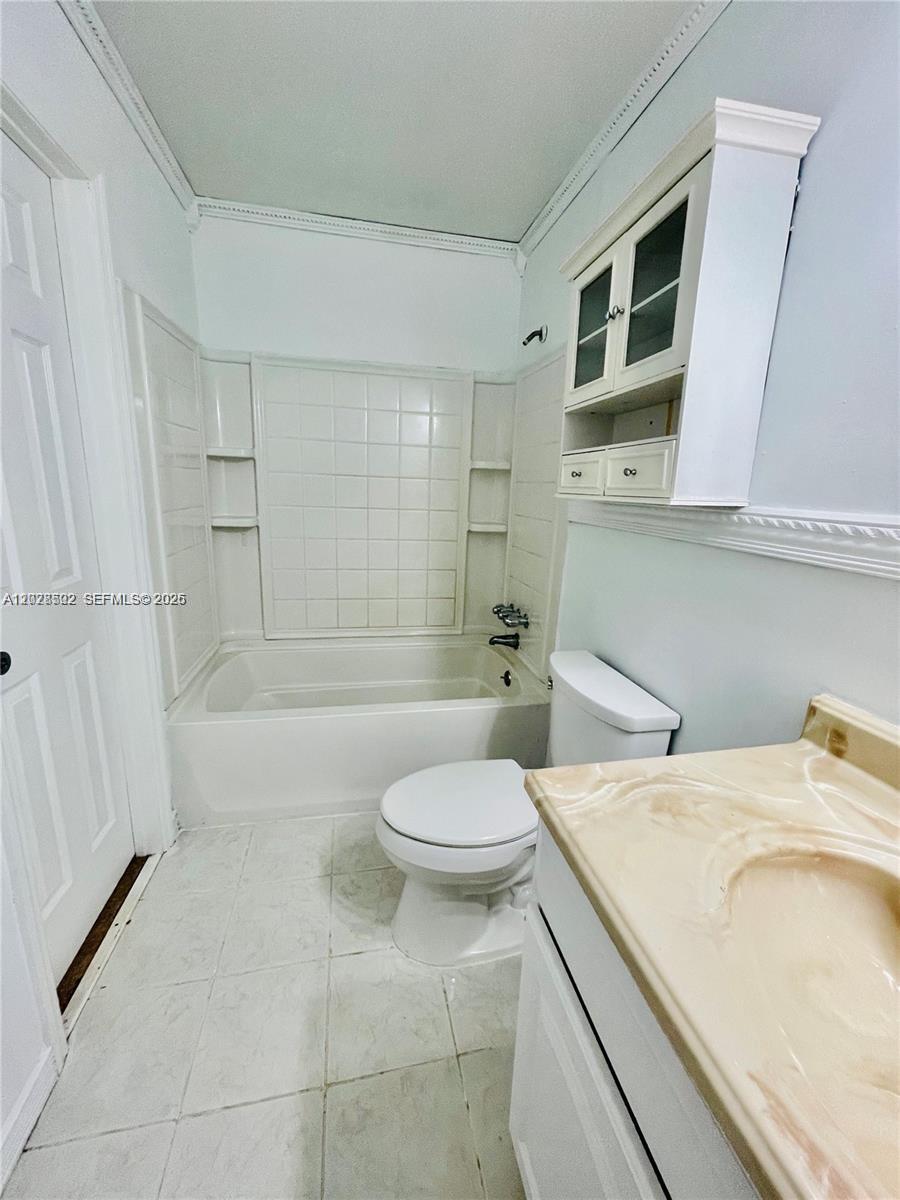 This bathroom features a white tub-shower combination, a toilet, and a vanity with a countertop — 5809 NW 21st St # A, Lauderhill FL 33313, LAUDERHILL, FL