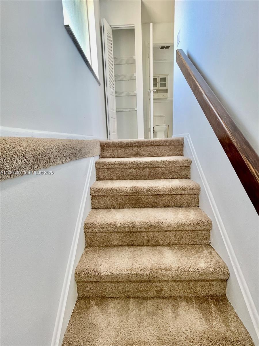 A carpeted staircase leads to a hallway with a closet and a bathroom — 5809 NW 21st St # A, Lauderhill FL 33313, LAUDERHILL, FL
