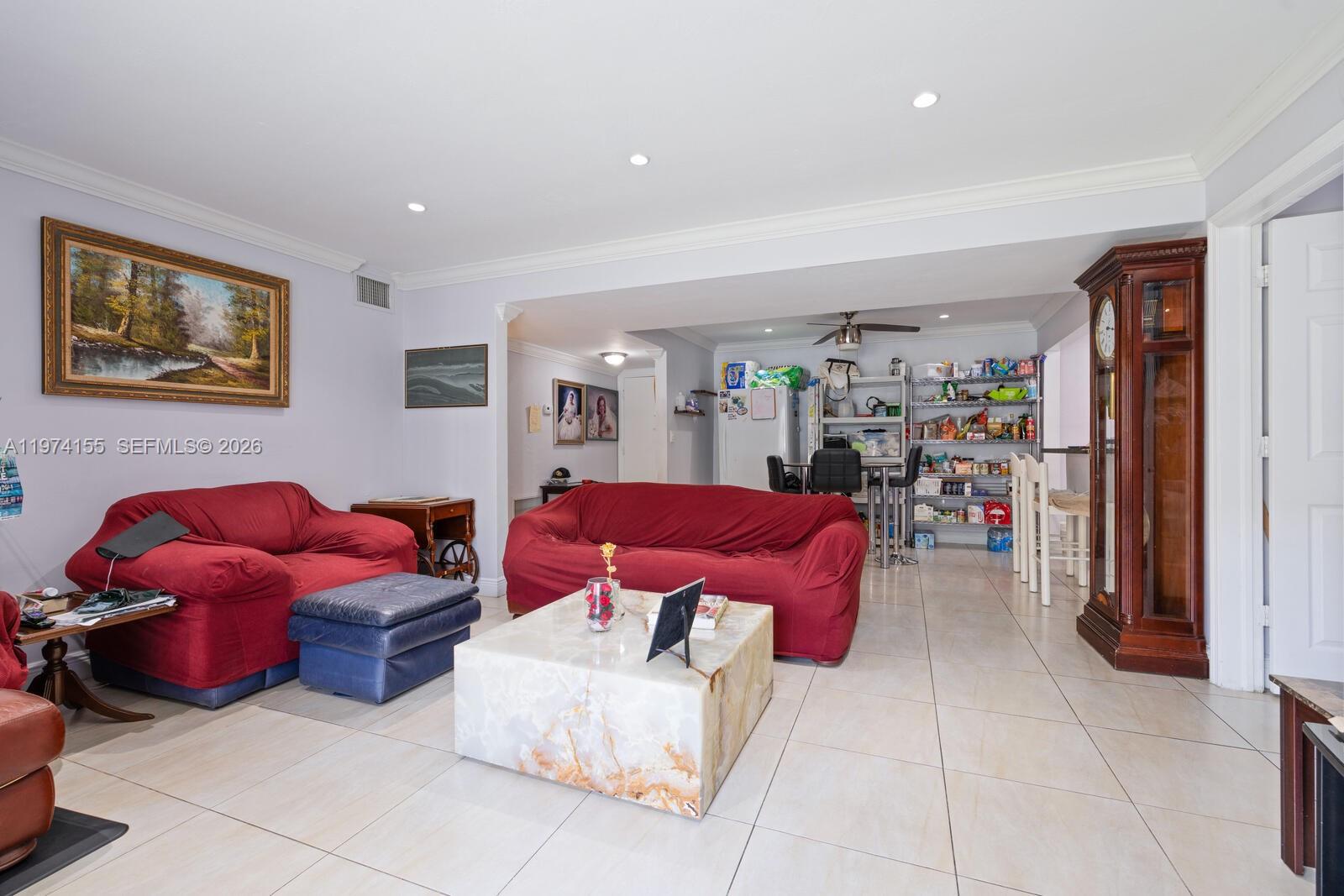A living room features red sofas, a stone coffee table, and a tall grandfather clock — 7401 SW 82nd st # 109s, Miami FL 33143, MIAMI, FL