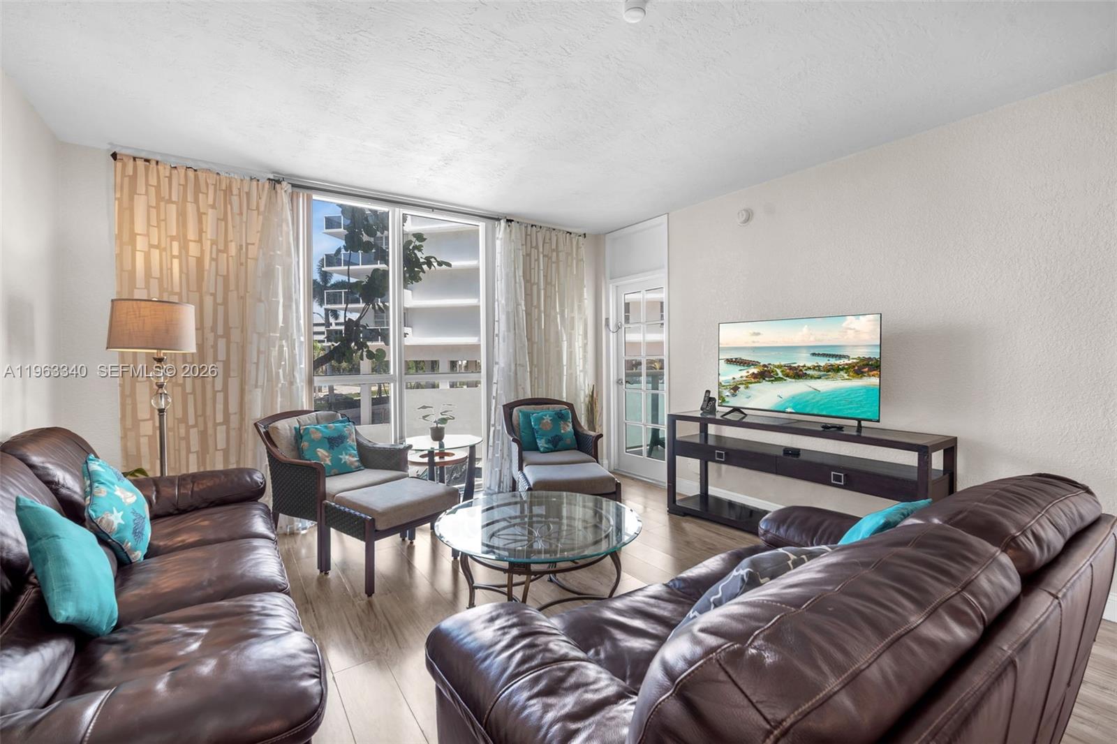 A living room features brown leather sofas, a glass coffee table, and a television console — 3801 S Ocean Dr # 2W, Hollywood FL 33019, HOLLYWOOD, FL