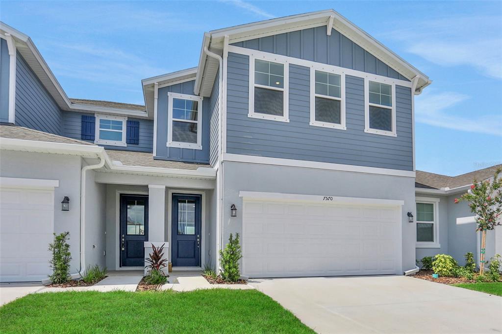 A two-story house with blue siding, a white garage, and two dark blue front doors — 7570 SEA OAK COURT, PARRISH, FL