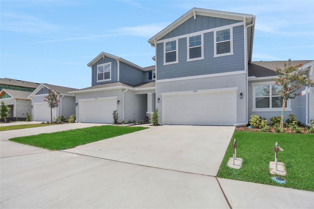A two-story suburban house with a two-car garage and light blue siding — 7570 SEA OAK COURT, PARRISH, FL