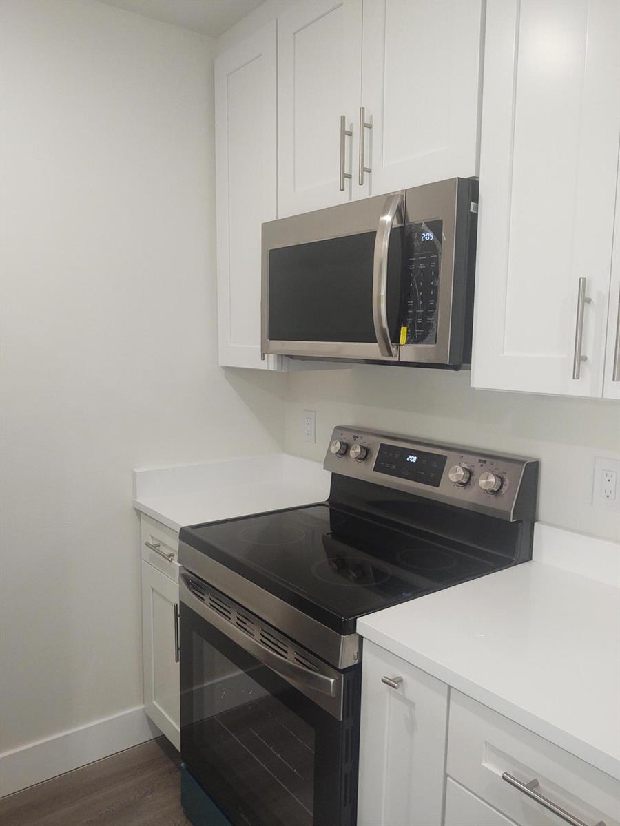 A kitchen features white cabinets, stainless steel appliances, and white countertops — 140 NW 70th # 2040, Boca Raton FL 33487, BOCA RATON, FL