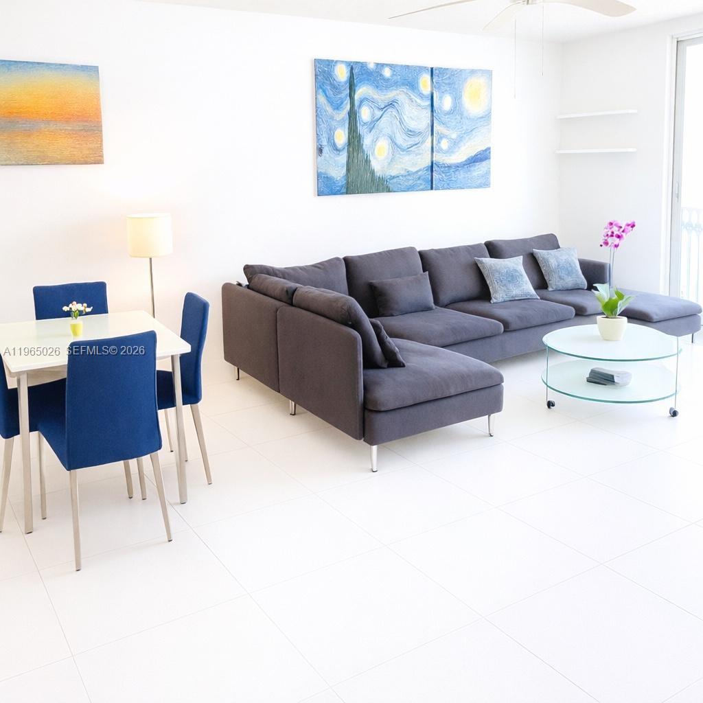 A living room features a gray sectional sofa, a dining set, and abstract wall art — 610 NE 12th Ave # 308, Hallandale Beach FL 33009, HALLANDALE BEACH, FL