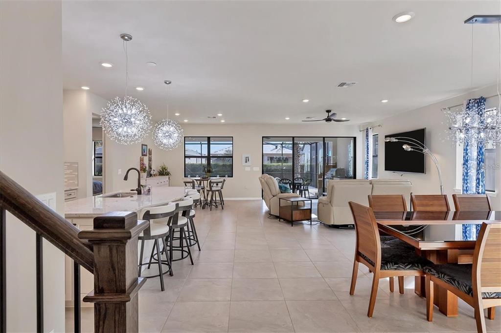 An open-concept living area features a kitchen with bar seating, a dining space, and furniture — 5721 SWEET LEAF WAY, SARASOTA, FL