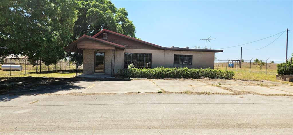 A single-story building with a brown roof, stucco exterior, and a concrete parking area — 321 DAVIS BROS ROAD, FROSTPROOF, FL