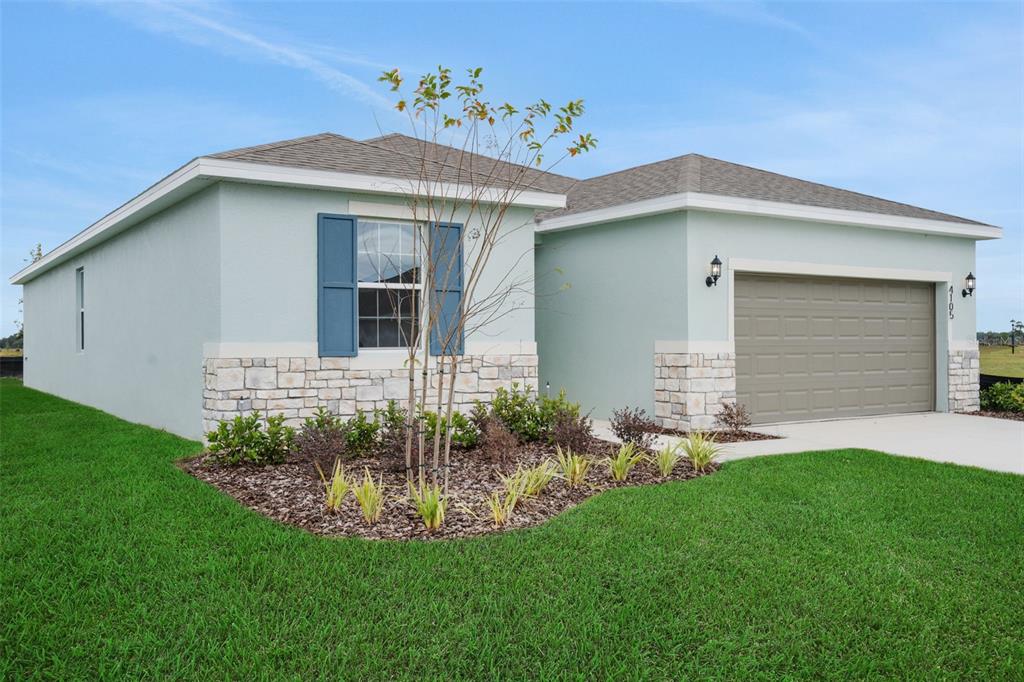 A single-story suburban house with a gray garage, stone accents, and a paved driveway — 7083 LANIER FALLS ROAD, DELAND, FL