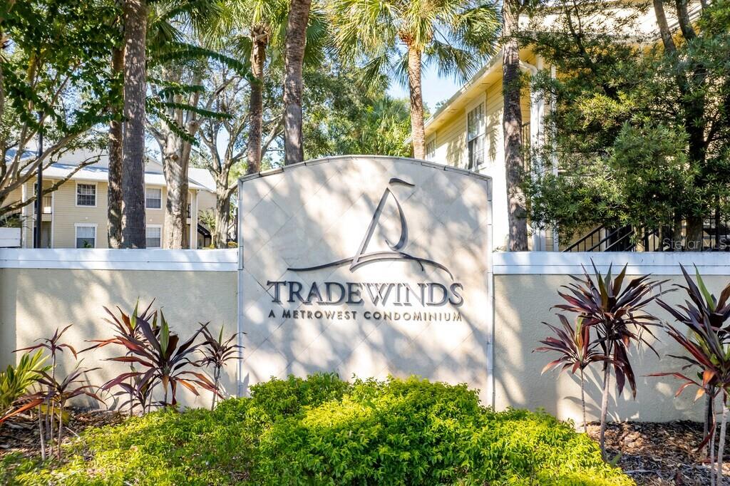 A sign for Tradewinds A Metrowest Condominium stands in front of a multi-story apartment building — 1091 S HIAWASSEE ROAD UNIT 234, ORLANDO, FL