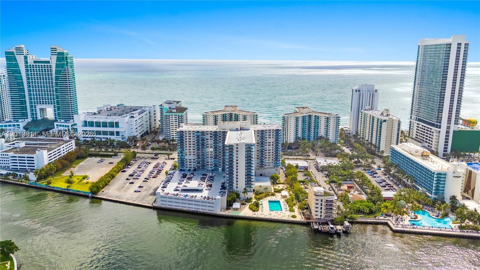 An aerial view shows multiple high-rise residential buildings along a coastline with a swimming pool — 3800 S Ocean Dr, Hollywood FL 33019, HOLLYWOOD, FL