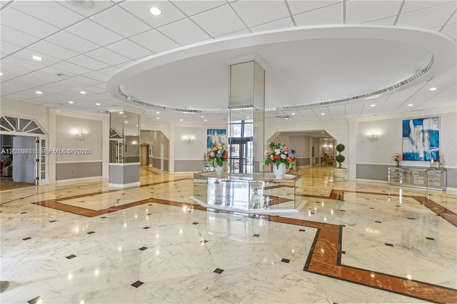 A spacious lobby features marble floors, a mirrored central pillar, and a circular ceiling design — 3800 S Ocean Dr, Hollywood FL 33019, HOLLYWOOD, FL