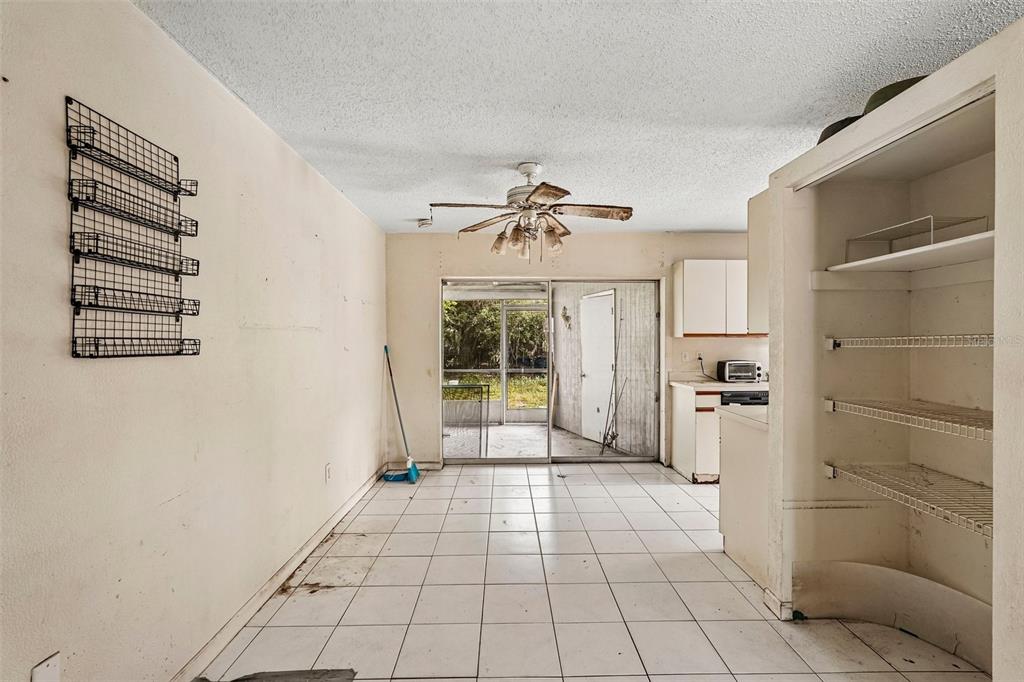 A dining area with white tile floors, a ceiling fan, and an open pantry shelf — 838 CORDELE AVENUE NW, PORT CHARLOTTE, FL