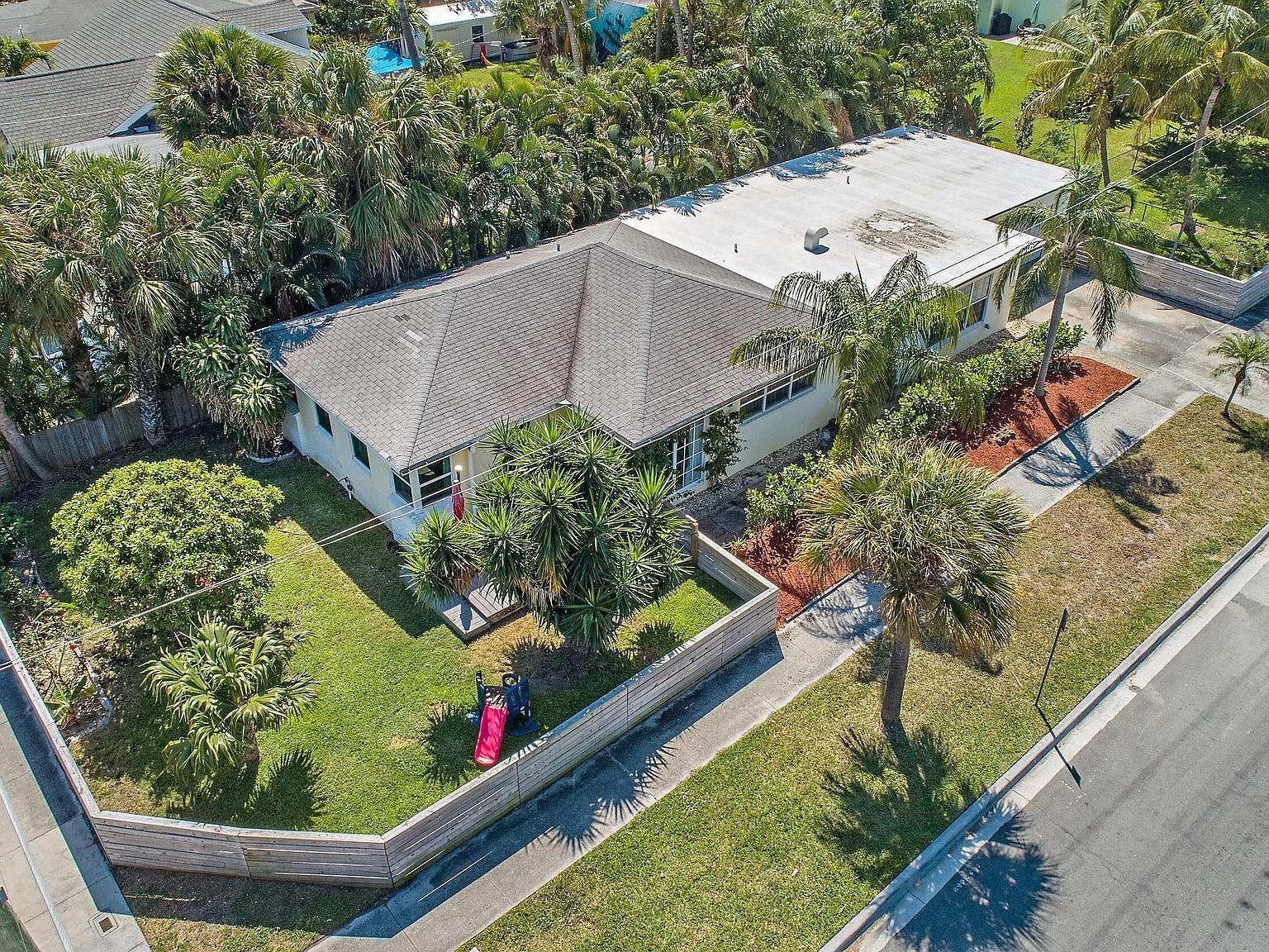 An aerial view of a single-story house with a fenced yard and palm trees — 400 45th Street, West Palm Beach FL 33407, WEST PALM BEACH, FL