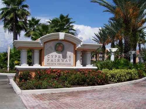 A stone entrance sign for Cypress Fairway Private Residences stands surrounded by palm trees and landscaping — 5447 VINELAND ROAD UNIT 1210, ORLANDO, FL